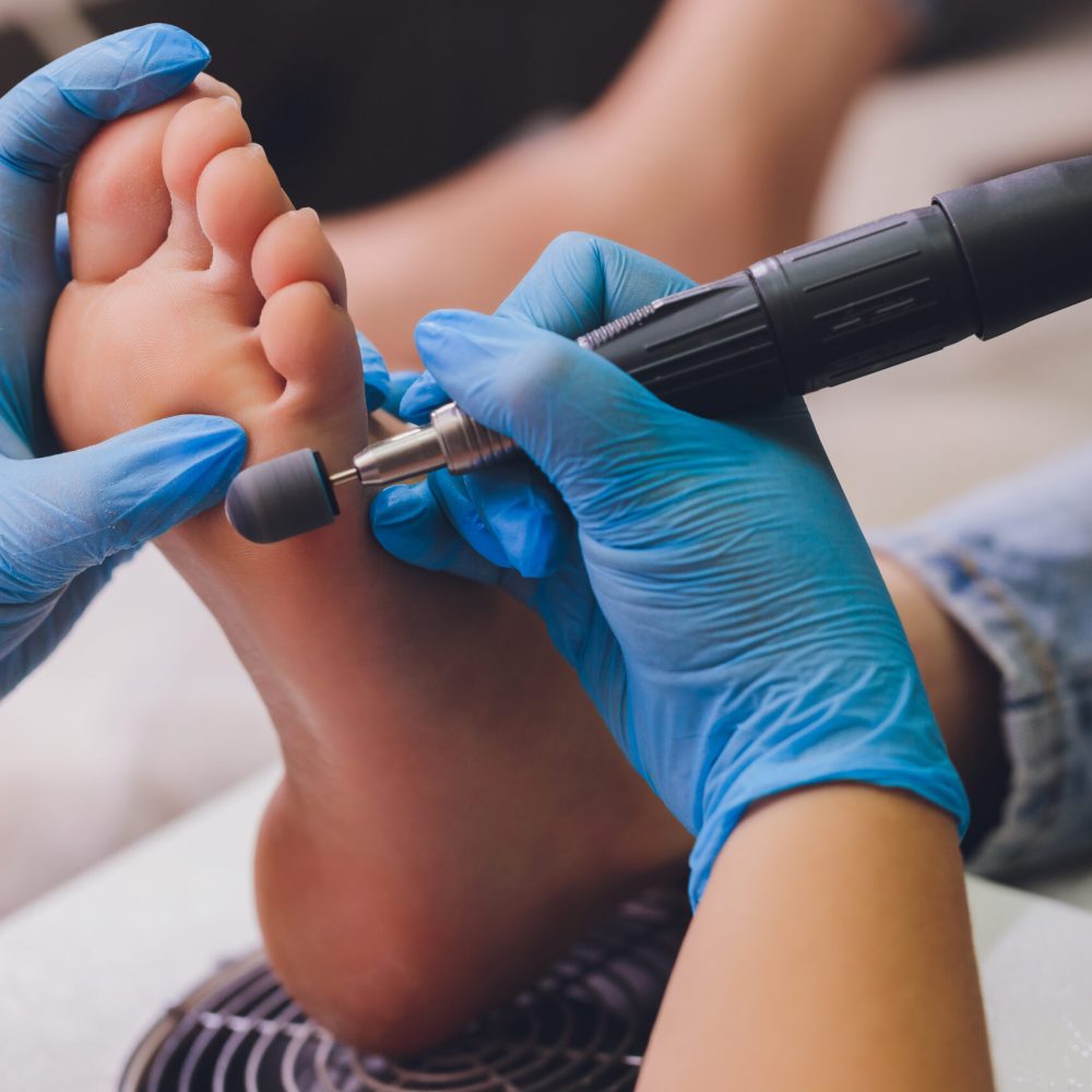 Process pedicure close-up, polishing feet, unrecognizable people. blurred face